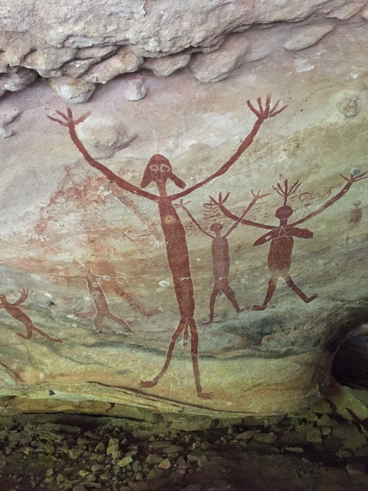 The main figure in this photo is a Timara known as 'the big boss of everybody, white man too', as told by an aboriginal elder. The larger figures to the right with the headdresses and their arms raised are cultural heros.