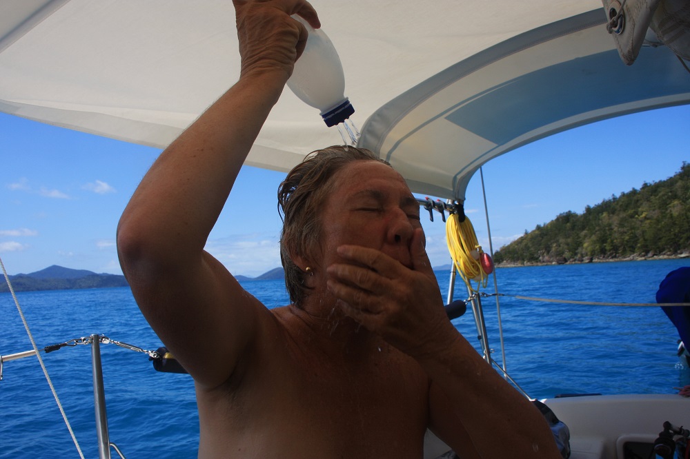 A 1-litre milk bottle makes for a very efficient shower. Our 'bath' is the ocean and the fresh water just for rinsing off the salt water. It's heated in the solar shower and feels like a million dollars, despite the look of anguish on my face!