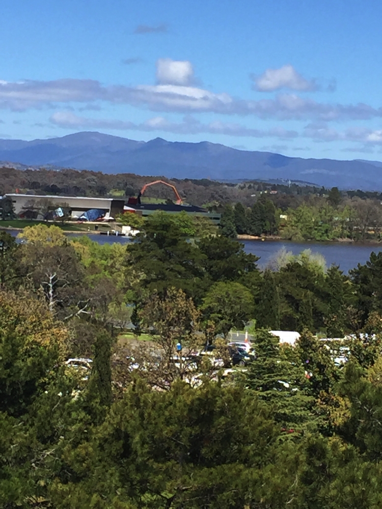 Canberra from the Floriade ferris wheel. Looking over Lake Burley Griffin, past the National Museum (the orange arch (mid-background) towards the hills.