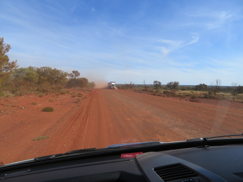 The cloud of dust that accompanies road trains is not fun. Pull over and stop - visibility too poor to keep driving.